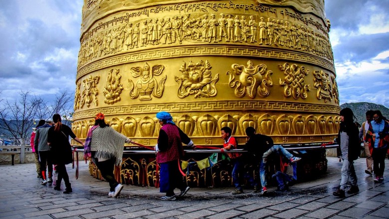 Người dân đẩy bánh xe cầu nguyện khổng lồ trên đồi Quy Sơn